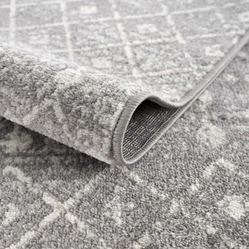 Close-up of the Marash KMRSH-4607 area rug showing its dark gray and ivory contemporary pattern and soft, textured pile. Fold
