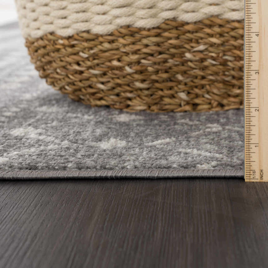 Close-up of the Marash KMRSH-4607 rug showing its dark gray and ivory colors, soft texture, and machine-made construction. Pile