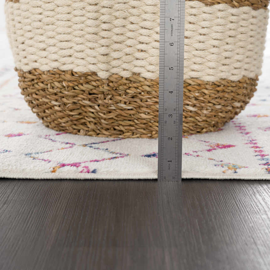 Close-up of the Marash KMRSH-4600 rug showing pile height. Off-white rug with colorful bohemian pattern and a measuring ruler. Pile