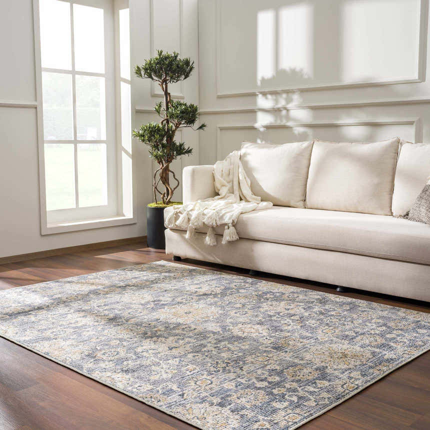 Living room scene with light gray Metin Area Rug, cream sofa, wood floors, and bright natural light. Roomscene-Rectangle