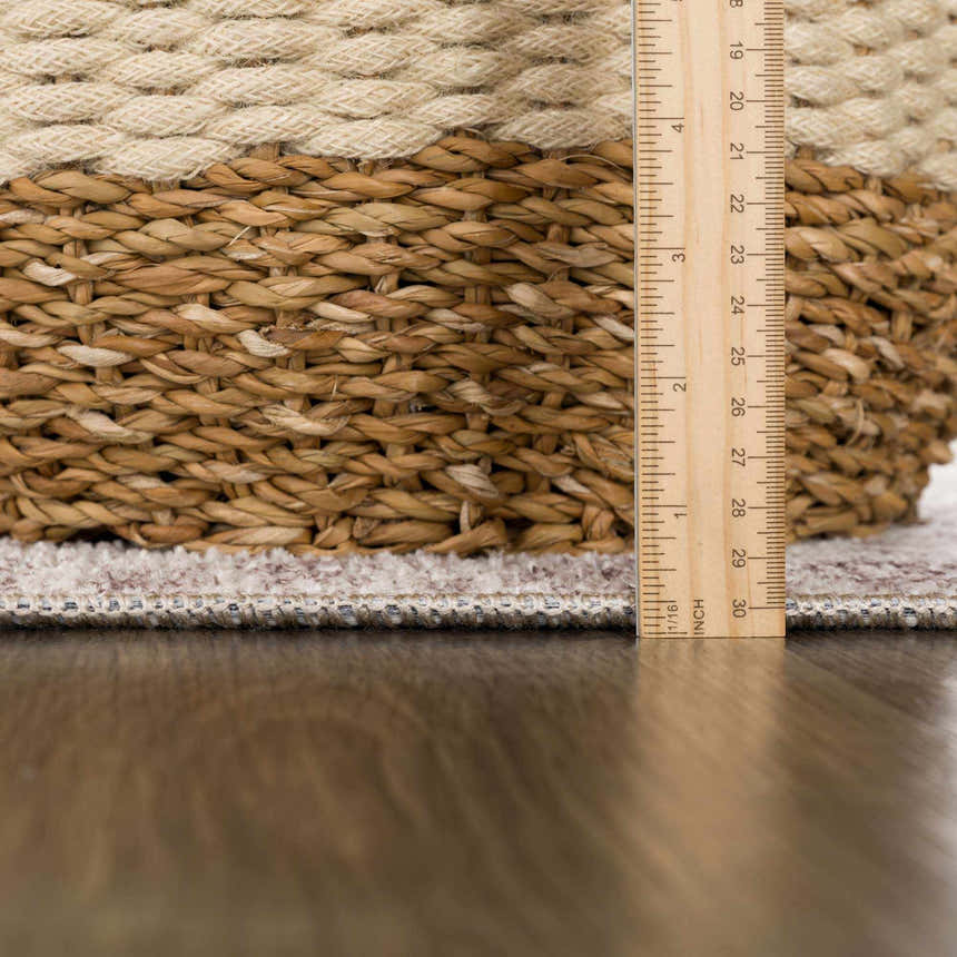 Close-up of the Mortye Cream & Brown Medallion Area Rug edge and pile height, with a ruler for scale. Pile