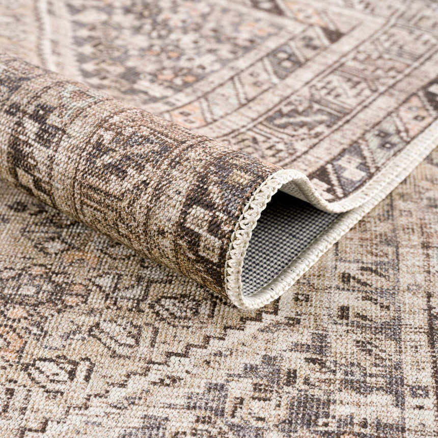 Close-up of the rolled Nadie Beige Medallion Area Rug showing its neutral colors, traditional pattern, and textured weave. Fold