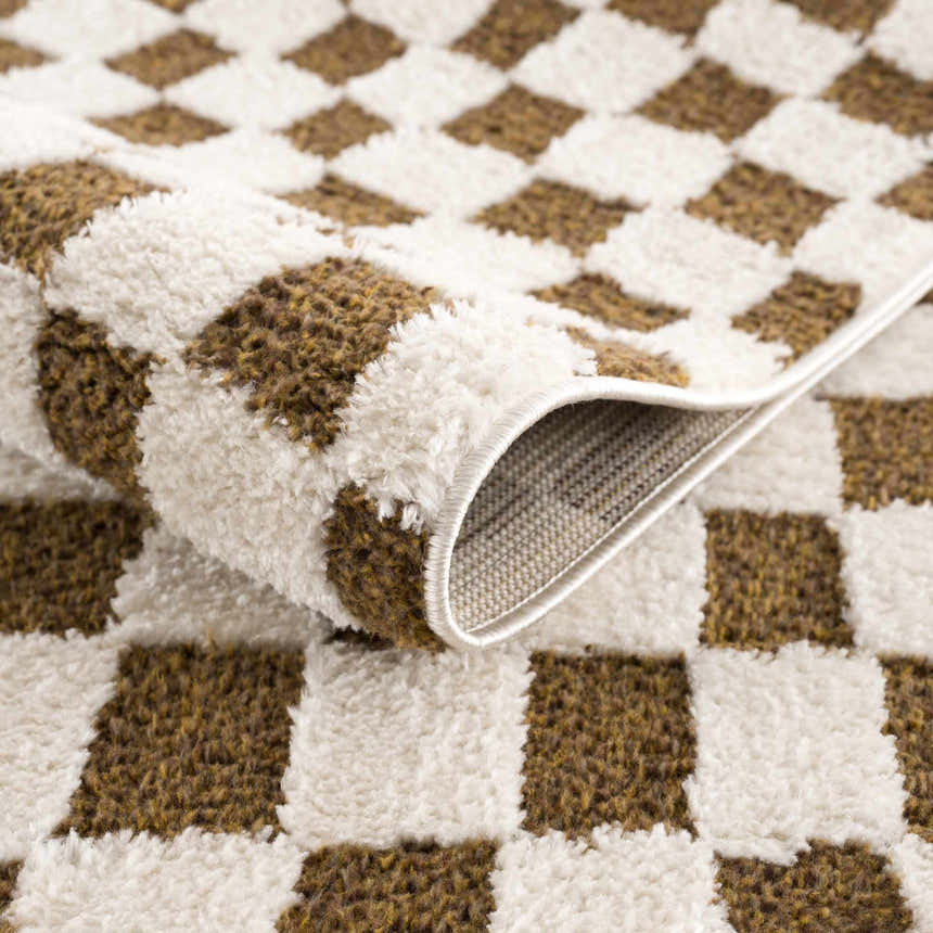 Close-up of the Lajos Brown Checkered Shag Rug showing the brown and white checkered pattern and soft, shag texture. Fold