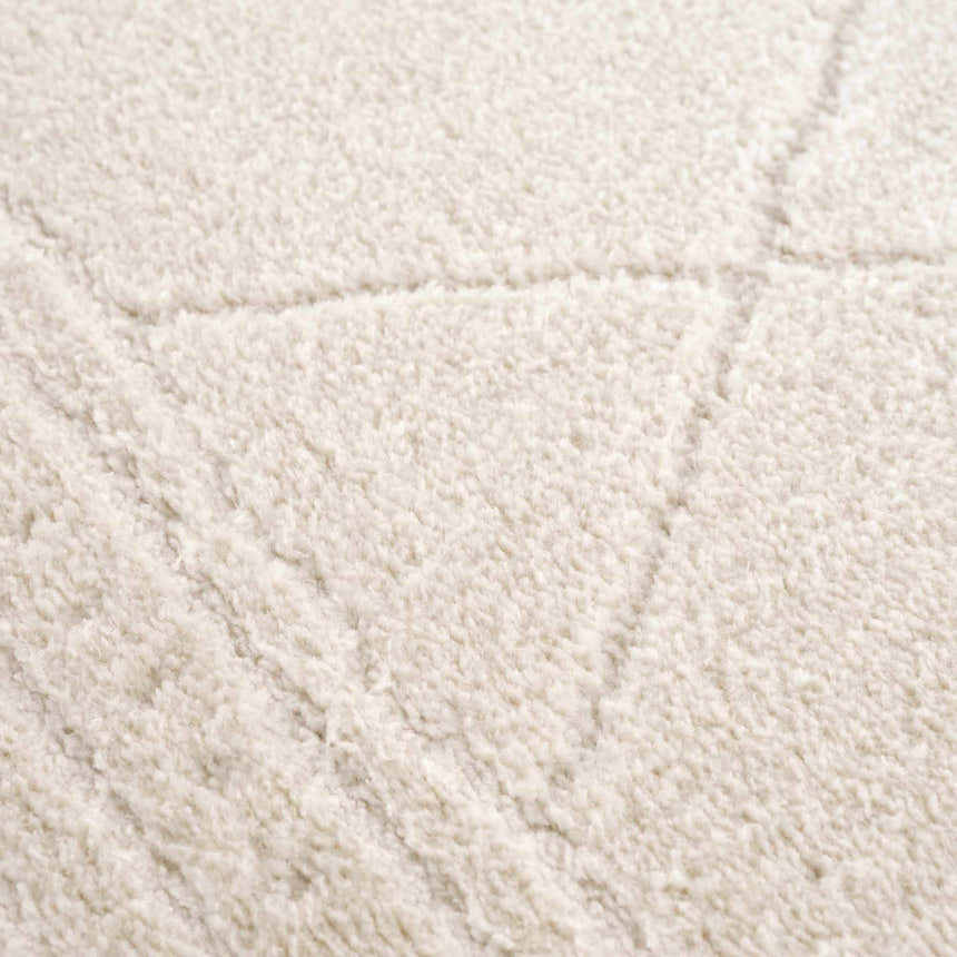 Close-up of the ivory Keone rug, showing its plush texture and subtle geometric pattern. Texture