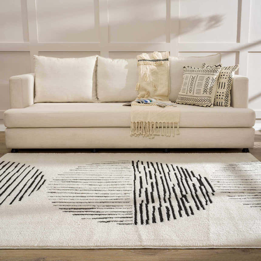 Living room scene with a cream sofa and the black and cream geometric Mahsa Area Rug. Roomscene-Rectangle