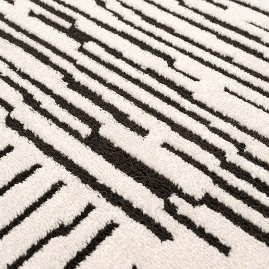Close up of the Mahsa Area Rug featuring a black and cream geometric design. Texture