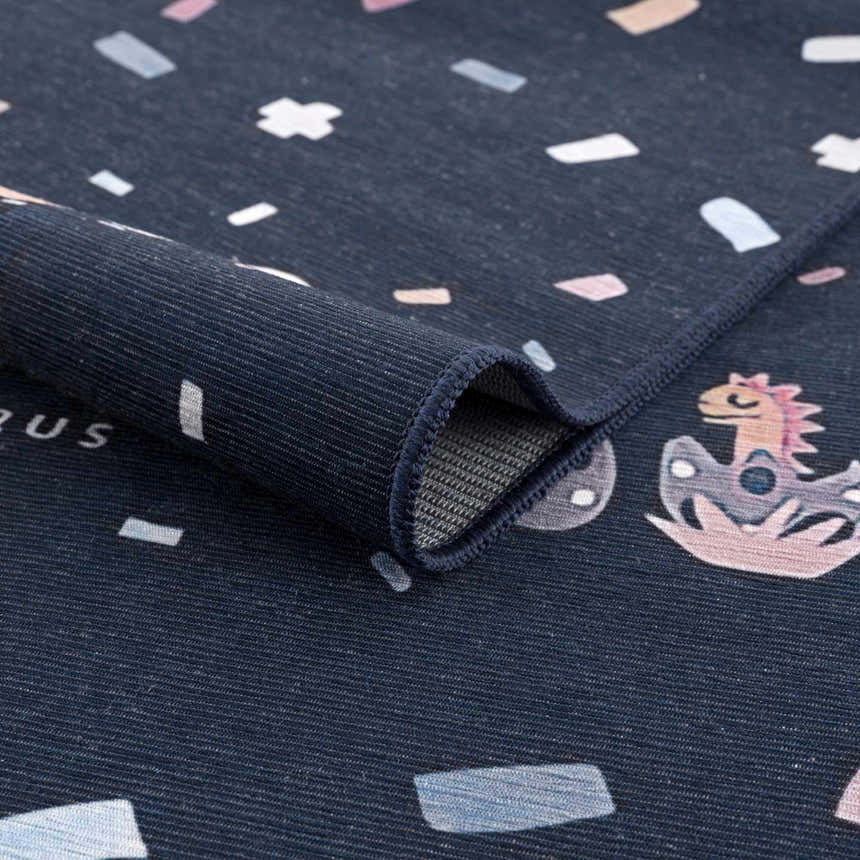 Close-up of the Milne Navy Dinosaur Washable Kids Rug, featuring a playful dinosaur pattern and a durable, textured weave. Fold