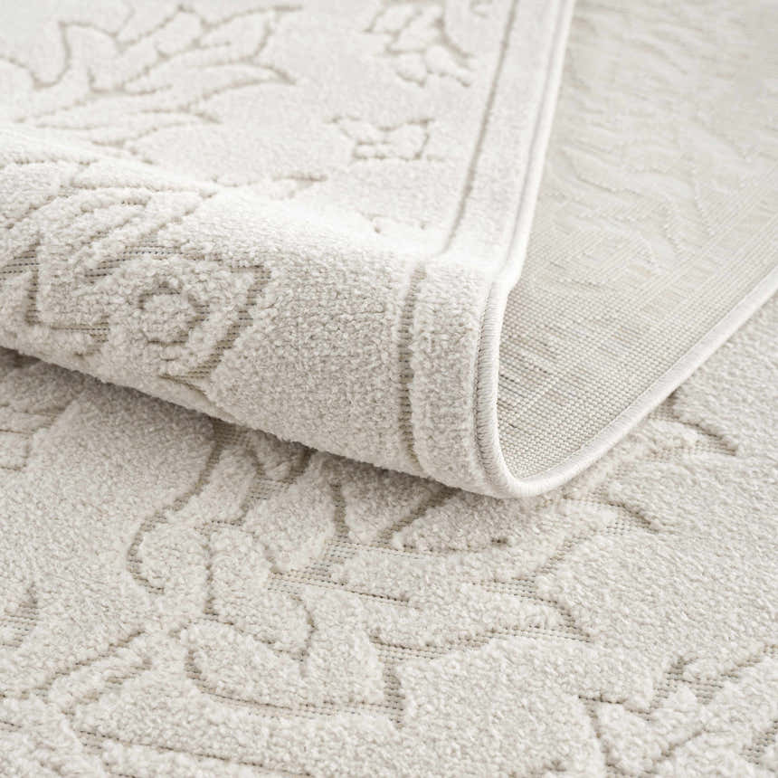 Close up of the off white Senekal 3D Outdoor Area Rug showing the geometric pattern and soft, textured pile. Fold