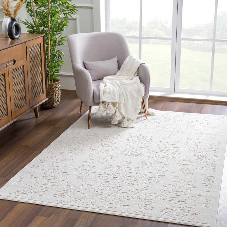 Living room scene with a gray armchair and the off-white Senekal 3D Outdoor Area Rug on hardwood floors. Roomscene-Rectangle