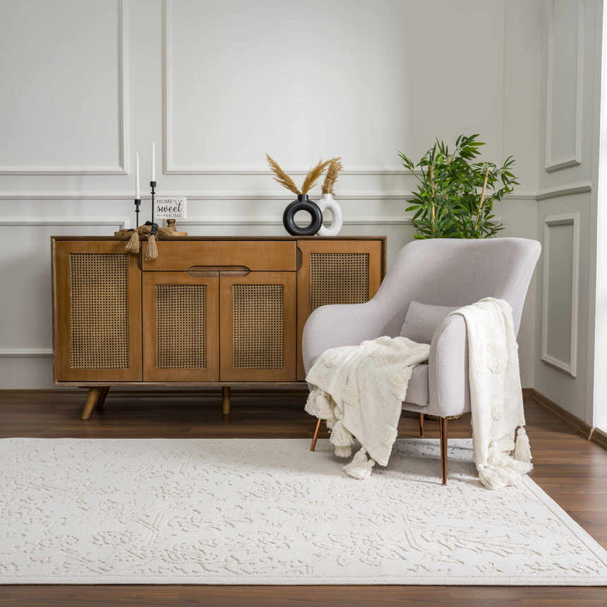 Living room scene with a Senekal 3D Outdoor Area Rug in off-white, a gray armchair, and a wooden cabinet. Roomscene-Rectangle