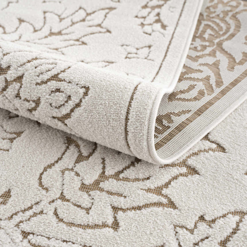 Close-up of the Tabuan 3D Outdoor Area Rug. Features a light peach floral pattern on a white thatch polypropylene rug. Fold