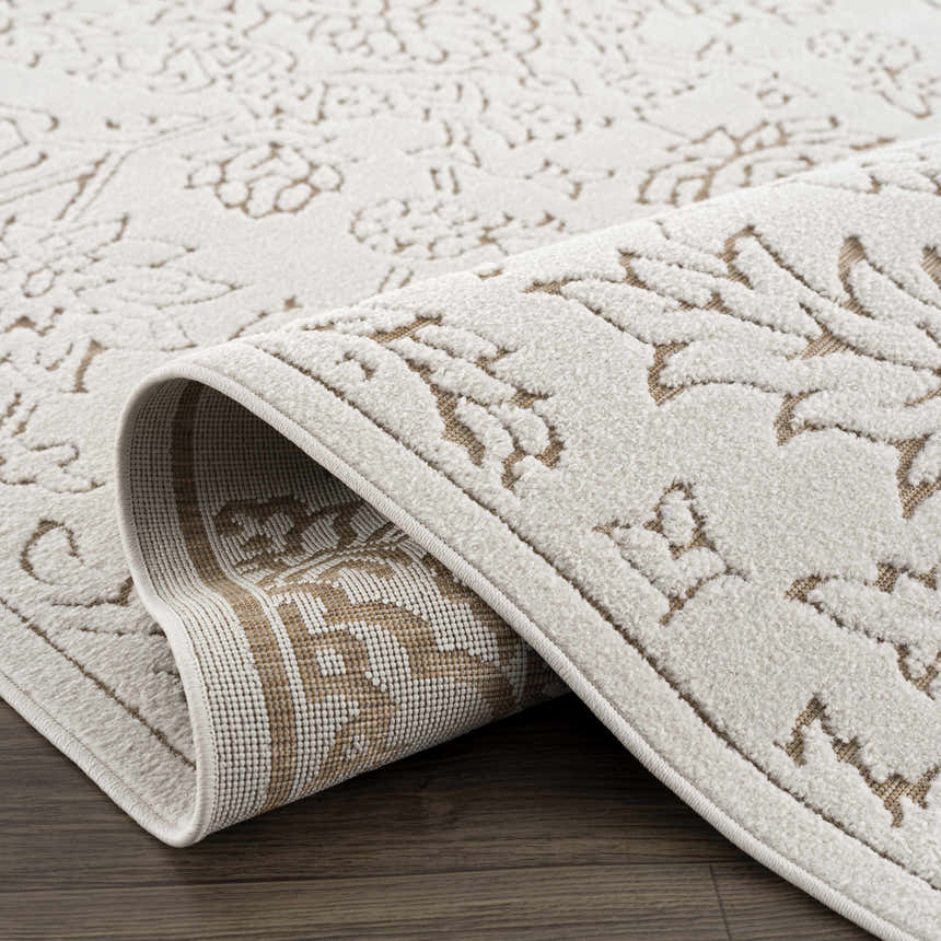 Close-up of the Tabuan 3D Outdoor Area Rug. Features a floral pattern in white thatch and nutmeg, rolled to show texture. Fold