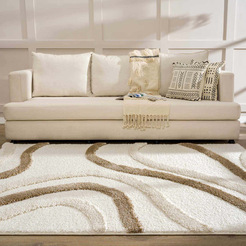 Living room scene with a cream sofa and the Espiye Area Rug in driftwood and white with a wavy pattern. Roomscene-Rectangle