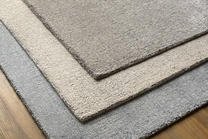 Close-up of the Phalaborwa Area Rug, a hand-loomed contemporary rug in gray, light beige, and tan. Wool and viscose texture. Styleshot