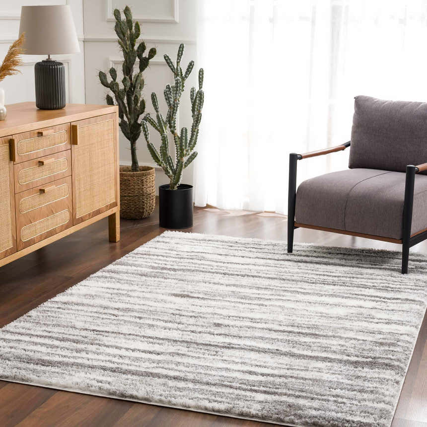 Living room scene with a gray chair and the gray and white Lotta Area Rug. Roomscene-Rectangle