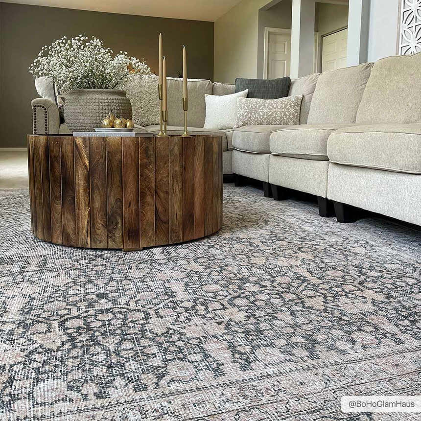 Living room scene with a gray sectional, wood coffee table, and the Hedda Boutique Washable Rug in a vintage-inspired design. Roomscene-Rectangle