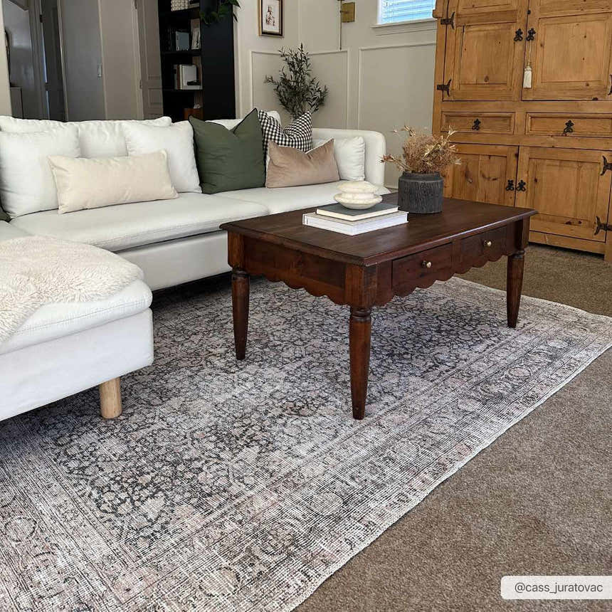 Living room scene with a white couch and Hedda Boutique Washable Rug in dark gray, brown coffee table, and a rustic wood cabinet. Roomscene-Rectangle