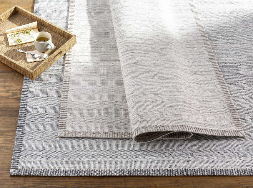 Close-up of the Nettleham Silver Viscose Rug showing its woven texture, charcoal and silver gray colors, and farmhouse style. Styleshot