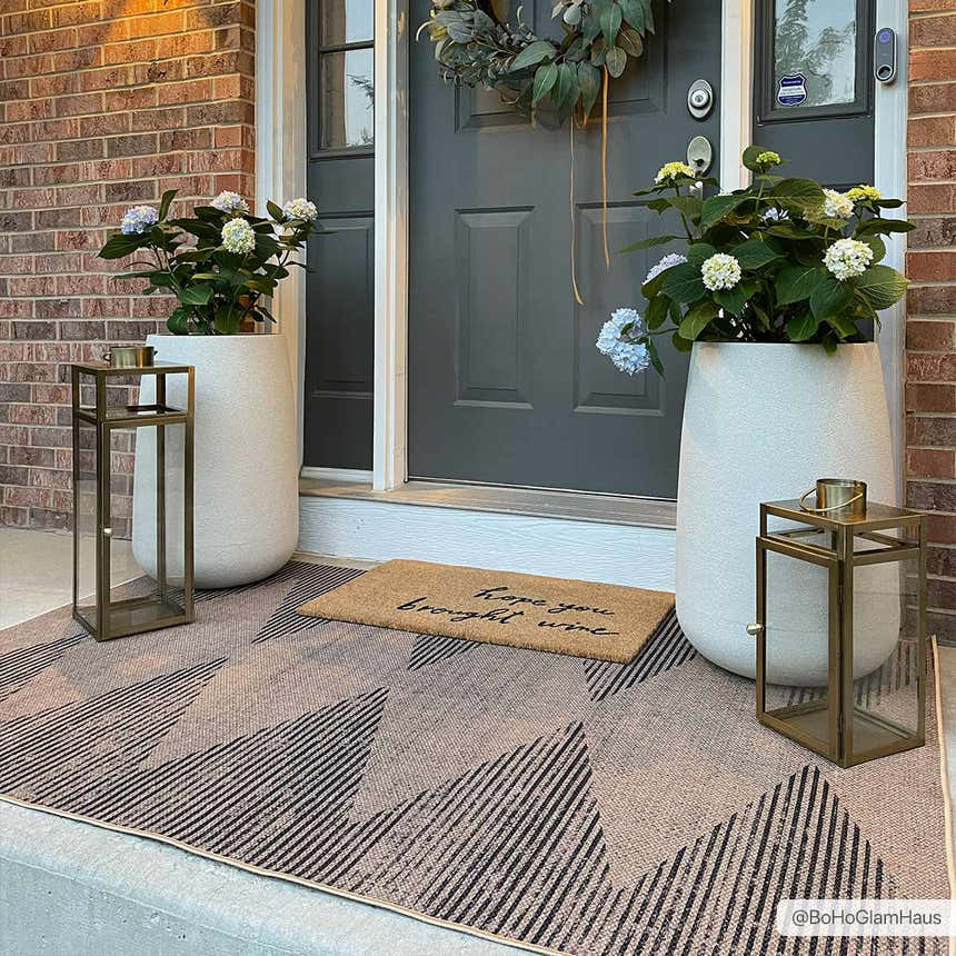 Stylish front porch featuring the Ijlal Washable Area Rug in camel and dark brown with geometric pattern. Roomscene-Rectangle