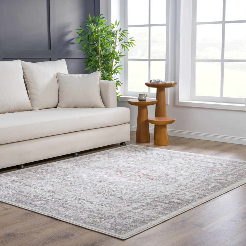 Bright living room scene with a gray and pink Damla Area Rug, cream sofa, and wood accent tables. Roomscene-Rectangle