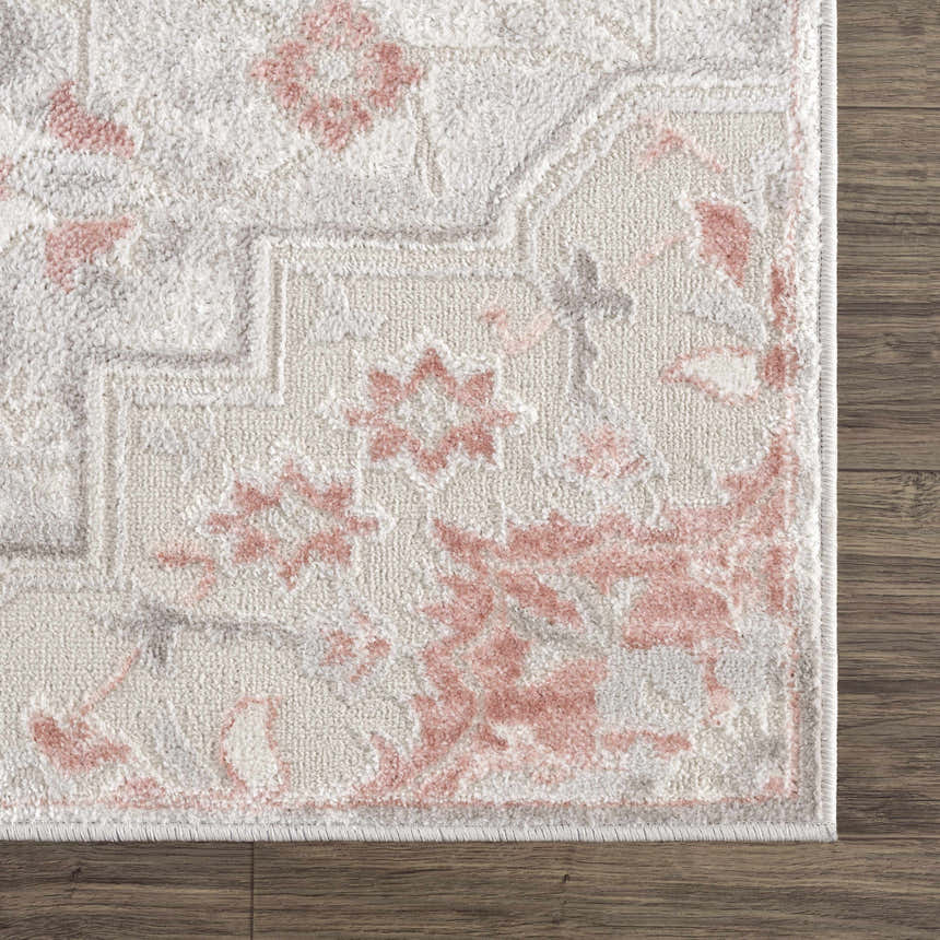 Close-up of the Calum Pink Floral Area Rug showing the floral pattern and soft texture on a wood floor. Swatch