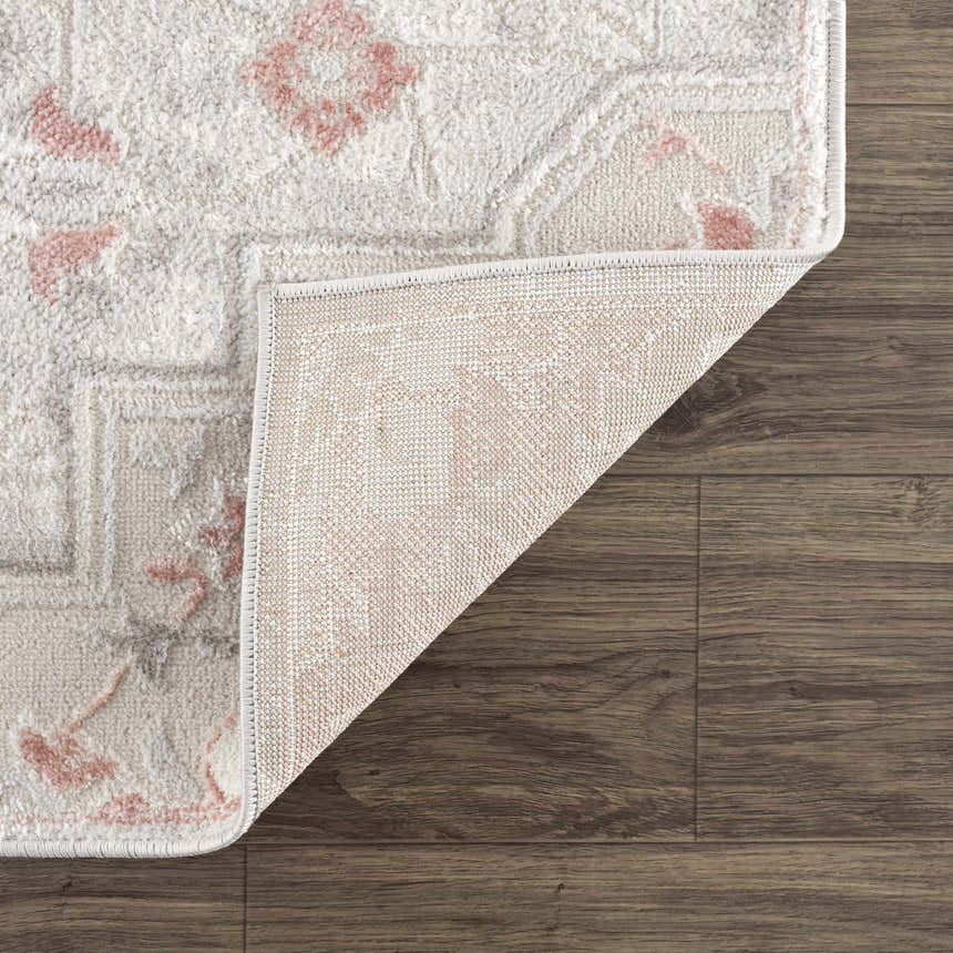 Close up of the Calum Pink Floral rug showing the pink floral pattern and the rug backing. Fold
