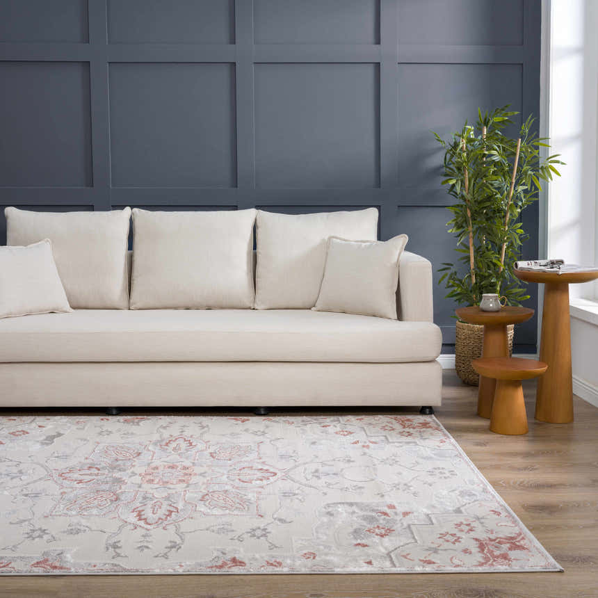 Living room scene with a Calum Pink Floral Area Rug, cream sofa, wood side tables, and navy accent wall. Roomscene-Rectangle
