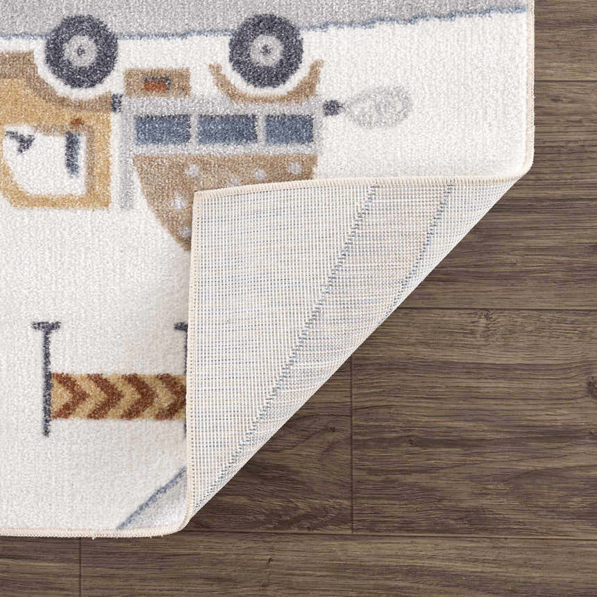 Close-up of the Olwen Washable Area Rug showing a truck pattern in blue, cream, and light gray on a white background. Fold