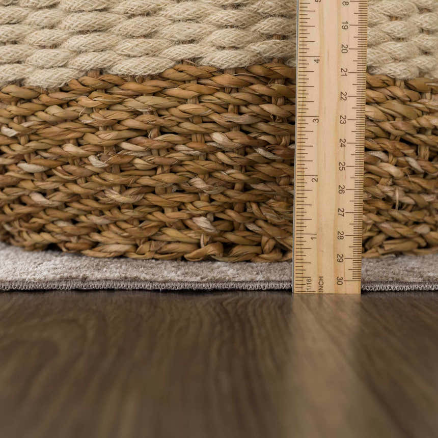 Close-up of Caditaan Washable Area Rug showing cream and brown woven texture and pile height with ruler for scale. Pile