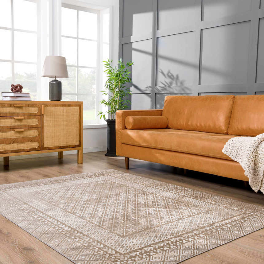 Living room scene with a brown leather sofa and Caditaan Washable Area Rug in cream and brown. Roomscene-Rectangle