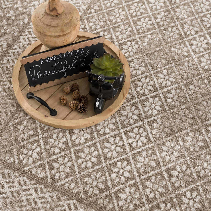 Close-up of the brown and cream Caditaan Washable Area Rug featuring a traditional floral pattern. Styleshot