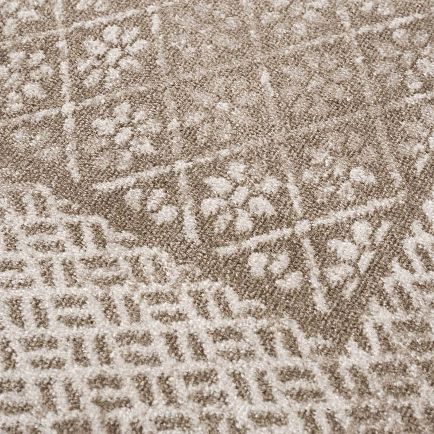 Close-up of the Caditaan Washable Area Rug. Brown and cream floral and geometric pattern. Soft, textured polyester. Texture