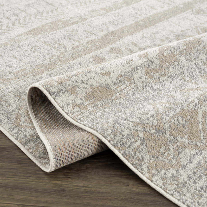 Close-up of the Tupsan Washable Area Rug showing its cream, light beige, and light gray contemporary pattern and soft texture. Fold