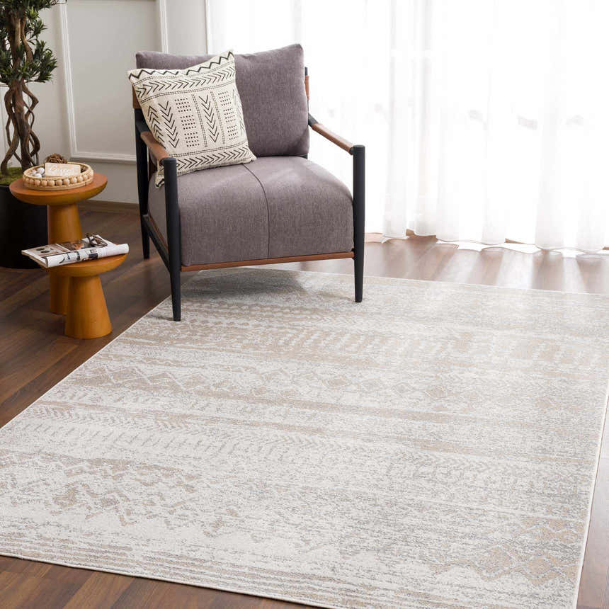 Living room scene with a Tupsan Washable Area Rug in cream and beige, a gray armchair, and wood side tables. Roomscene-Rectangle