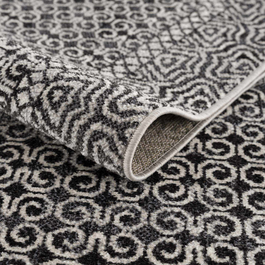 Close-up of the Coledale Black & White Washable Rug showing the oriental-inspired pattern and soft texture. Fold