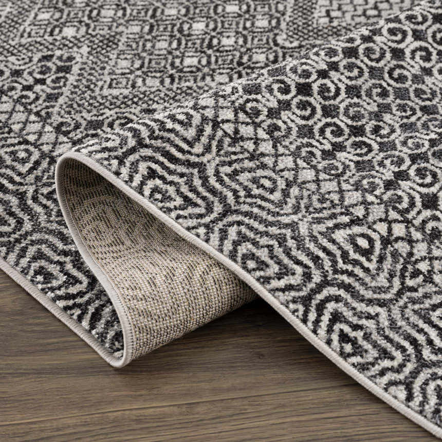 Close-up of the Coledale Black & White Washable Rug showing its geometric pattern and durable construction. Fold