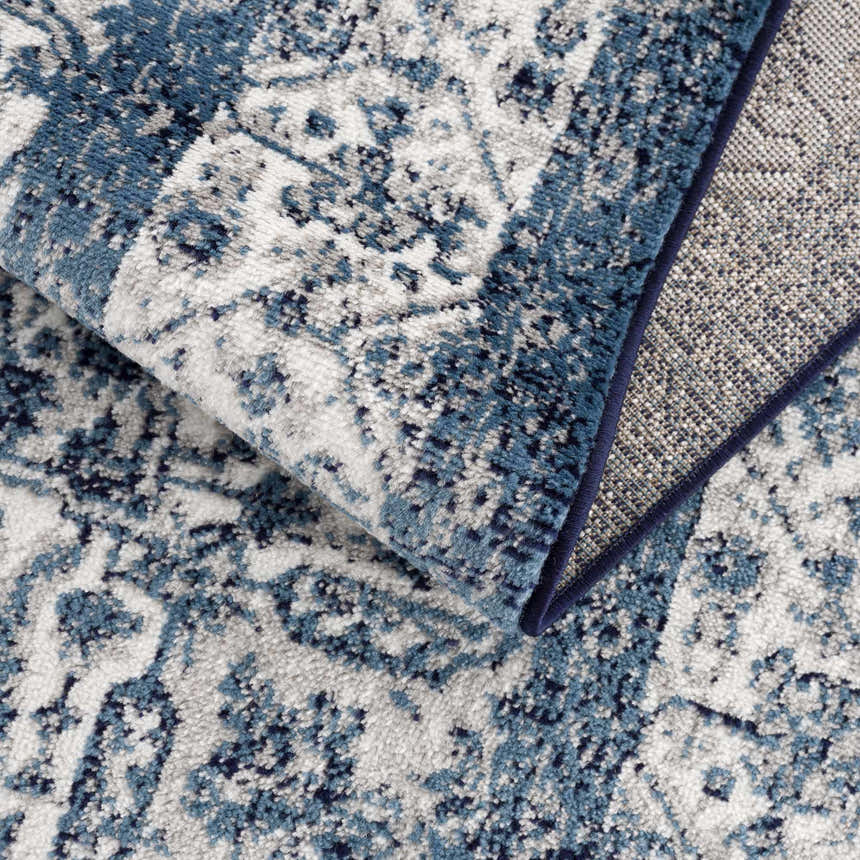 Close-up of the Billy Area Rug showcasing its blue and navy traditional Persian-style pattern and machine-woven texture. Fold