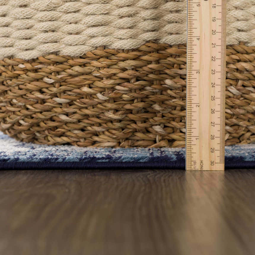 Close-up of the navy blue border and pattern of the Billy Area Rug, with a ruler for scale. Pile