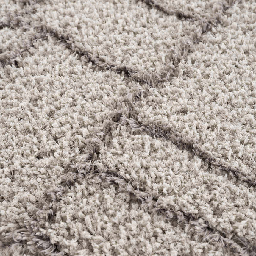 Close-up of the plush Andia Gray Area Rug, showing its geometric shag design and soft, silver and gray polyester texture. Texture