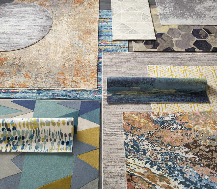 Overhead shot of various rugs with abstract patterns and textures, including the Alvaton Abstract Blue Rug. Styleshot