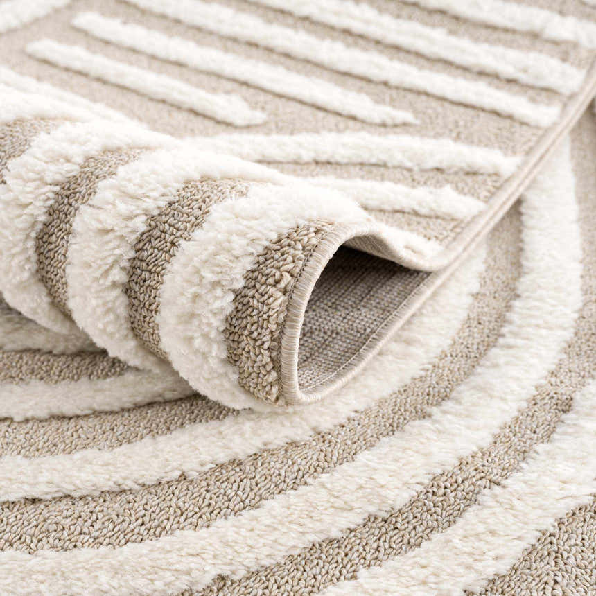 Close-up of the Moise Area Rug showing its beige and cream stripes, machine-woven texture, and rolled edge detail. Fold