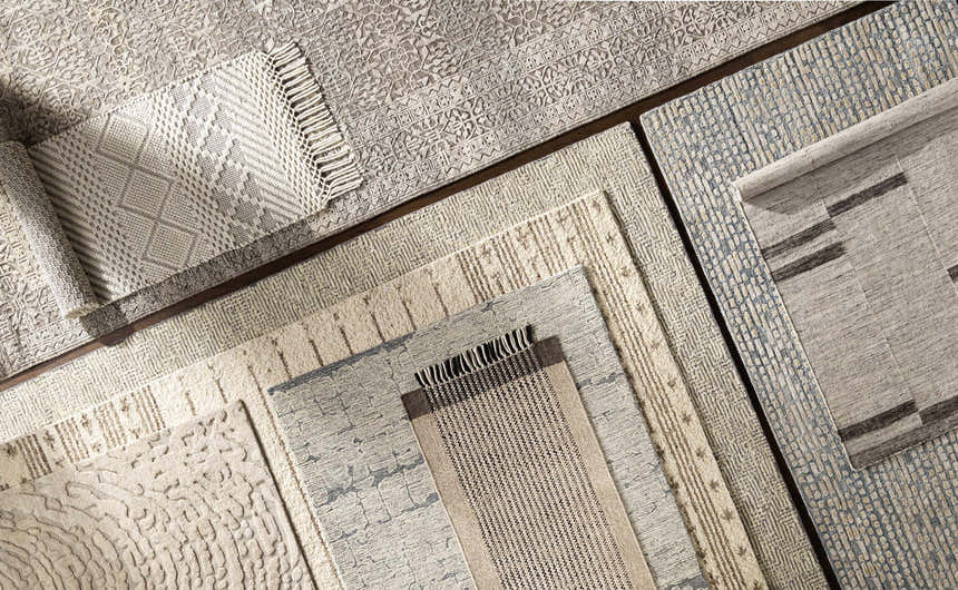 Close-up of multiple Delahey Area Rugs in charcoal, cream, and tan with contemporary patterns and textures. Styleshot