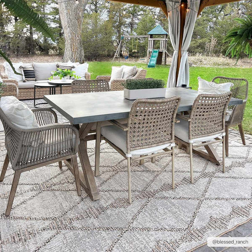 Outdoor dining area with a Nyla Bone & Tan Textured Performance Rug, table, and chairs. Farmhouse style. Roomscene-Rectangle