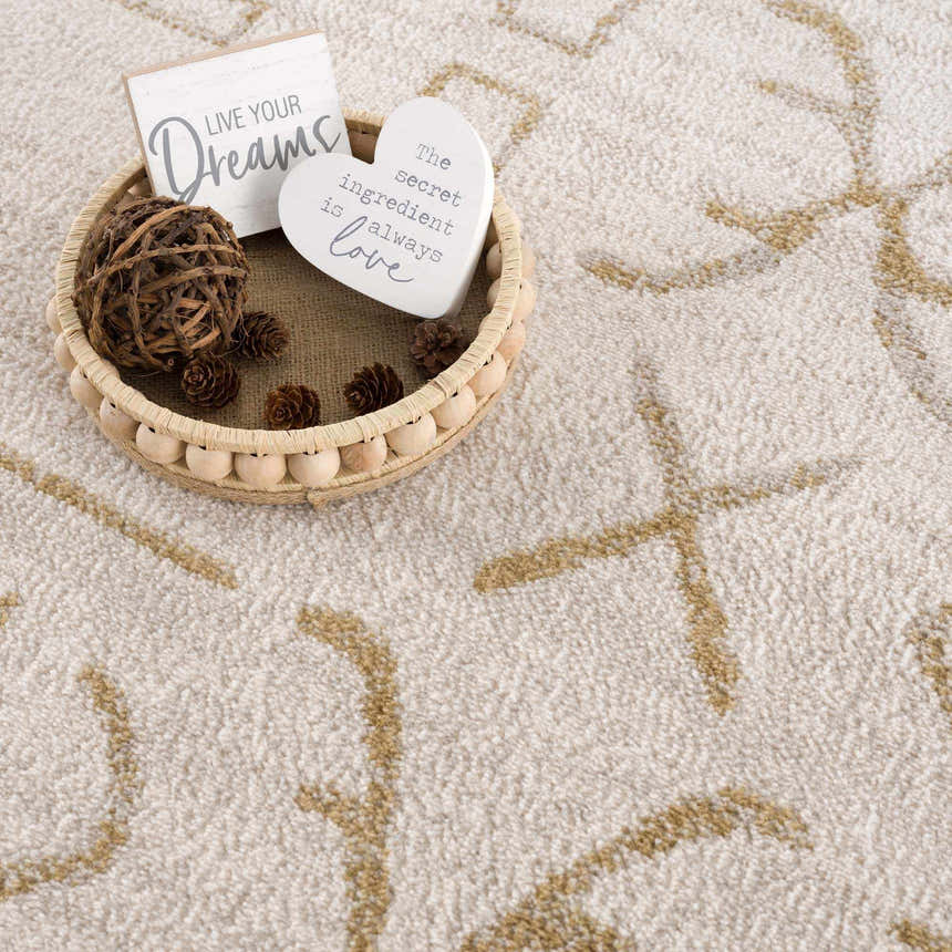 Close up of Azzan Cream & Gold Area Rug showing the subtle gold geometric pattern and soft, textured cream background. Styleshot