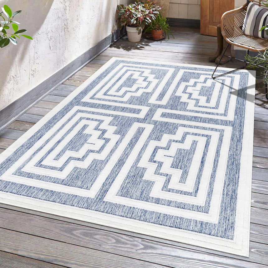 Outdoor patio scene with a blue and white geometric Yves Blue Outdoor Rug. Roomscene-Rectangle