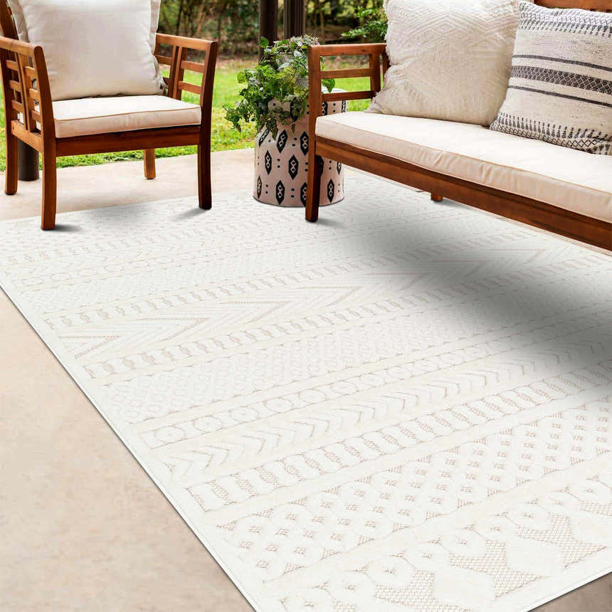 Outdoor patio scene with wood furniture and a cream Southwestern style Jove Cream Outdoor Rug. Roomscene-Rectangle