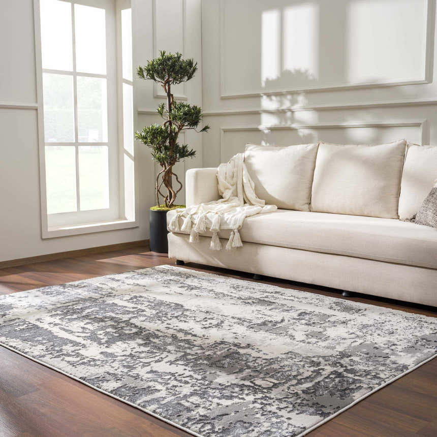 Living room scene with Junko Gray & Blue Marble Area Rug, beige sofa, wood floors, and natural light. Roomscene-Rectangle