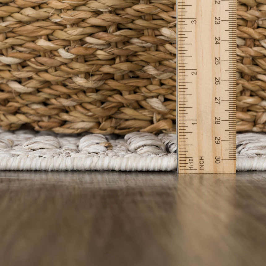 Close-up of Nyla Bone rug texture with ruler showing pile height. Bone colored polypropylene rug. Pile