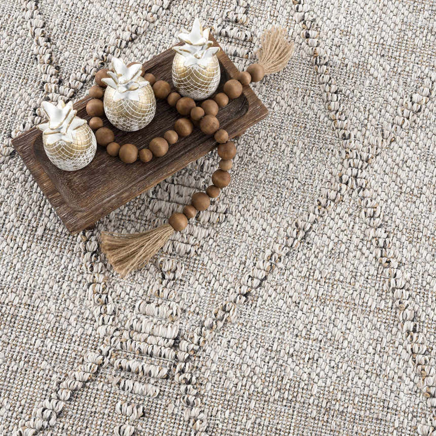 Close-up of Nyla Bone Indoor Outdoor Rug showing woven texture and raised geometric pattern in neutral bone color. Styleshot