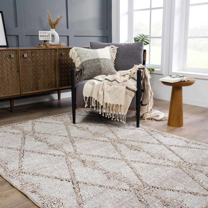 Living room scene with Nyla Bone & Tan Textured Performance Rug, gray chair, wood cabinet, and natural light. Roomscene-Rectangle